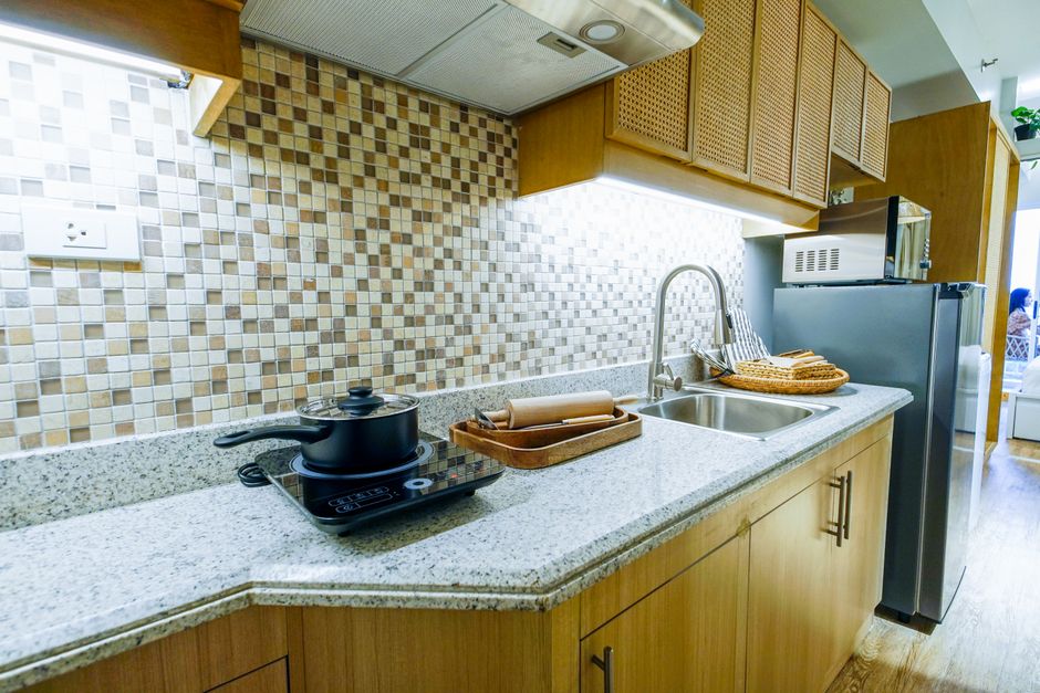 Bright modern kitchen with granite countertop and stainless steel appliances.