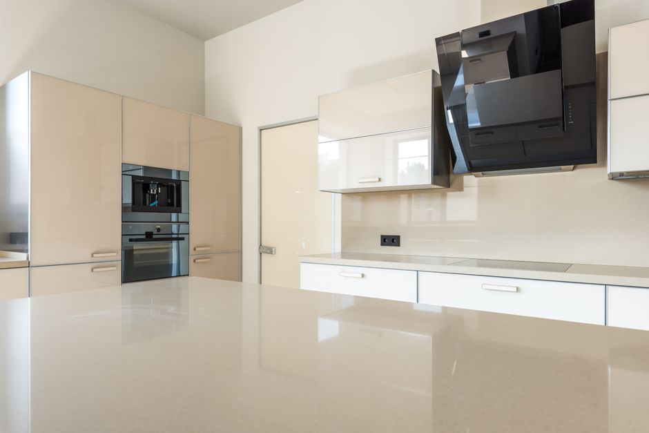 Sleek and spacious modern kitchen design featuring glossy cabinets and high-end appliances.